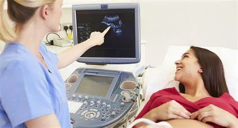 Ultrasound therapy session in Prairie Village, KS, with a healthcare professional pointing at an ultrasound monitor while a patient smiles, indicating non-invasive pain relief and healing.